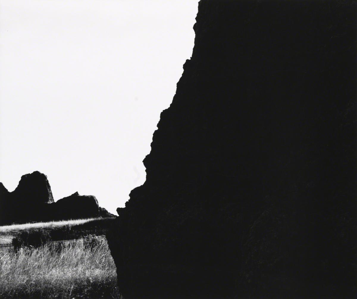 high contrast black and white photograph of rocky outcroppings that divide the image in two