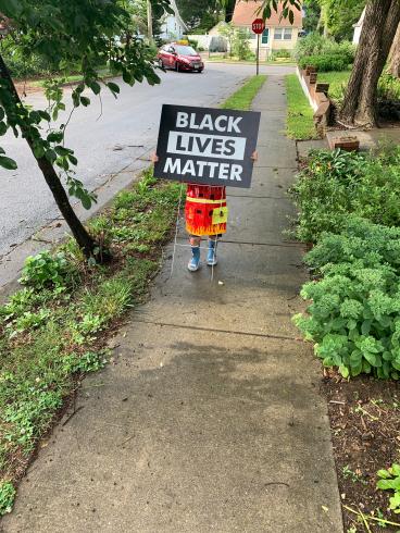 Photograph of a small child holding a "Black Lives Matter" sign