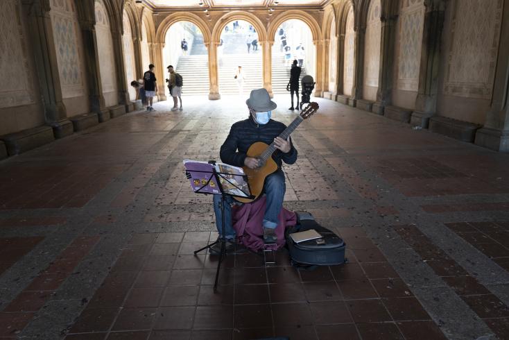 Photograph of person playing the guitar in an empty tunnel