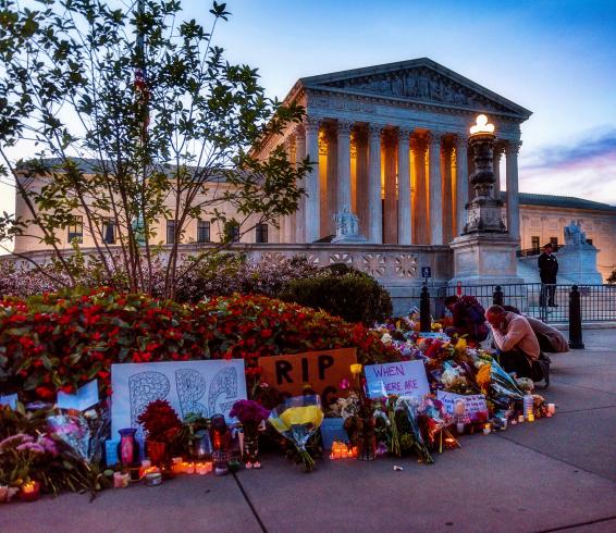 Photograph of flowers and candles in front of the Supreme Court