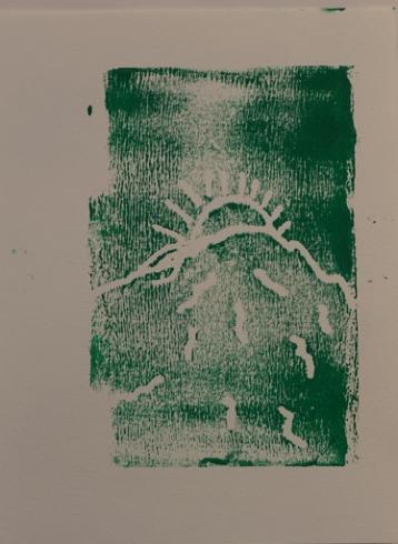 Green print with the sun behind a mountain.
