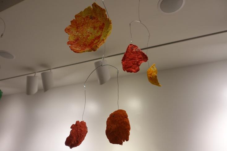Mobile with paper mache shapes (orange and yellow).