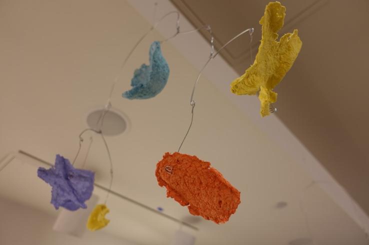 Mobile with paper mache shapes (orange, yellow, blue, and purple).