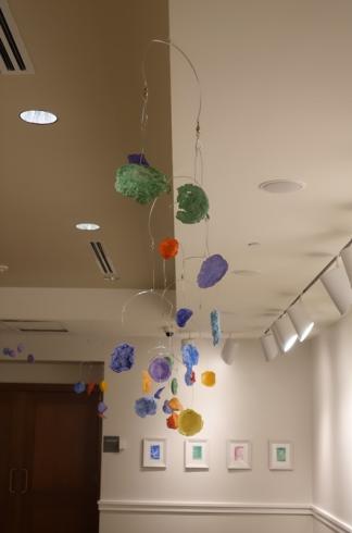 Mobiles with paper mache shapes, displayed from the ceiling.