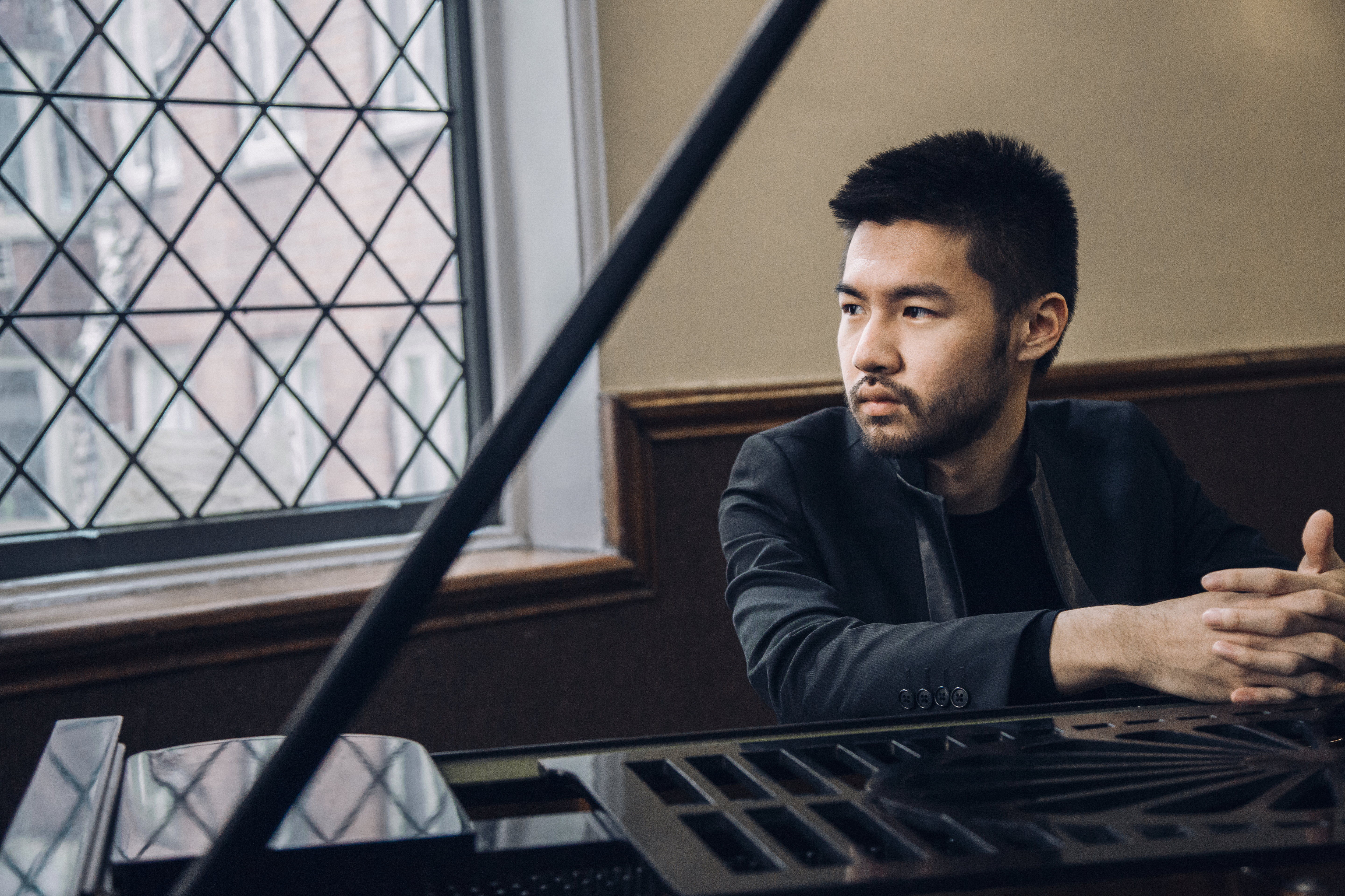 Photo of man sitting behind piano 