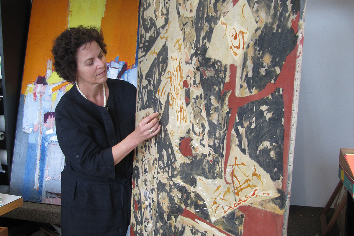 A conservator looks at a work on paper