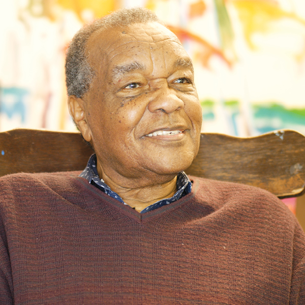 Photo portrait of David Driskell smiling, looking off to right