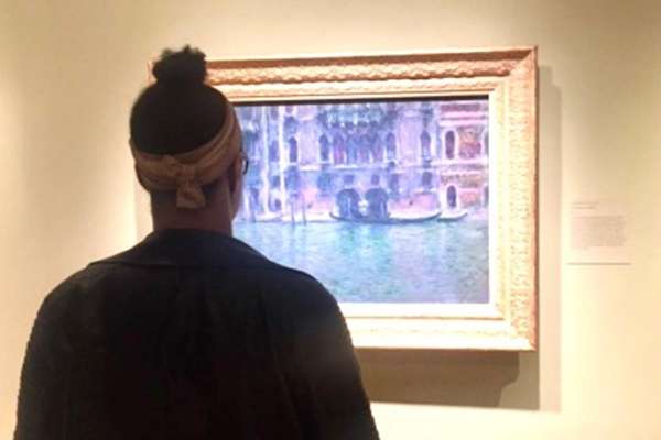 Photo of a someone looking at a painting of Venice by Monet