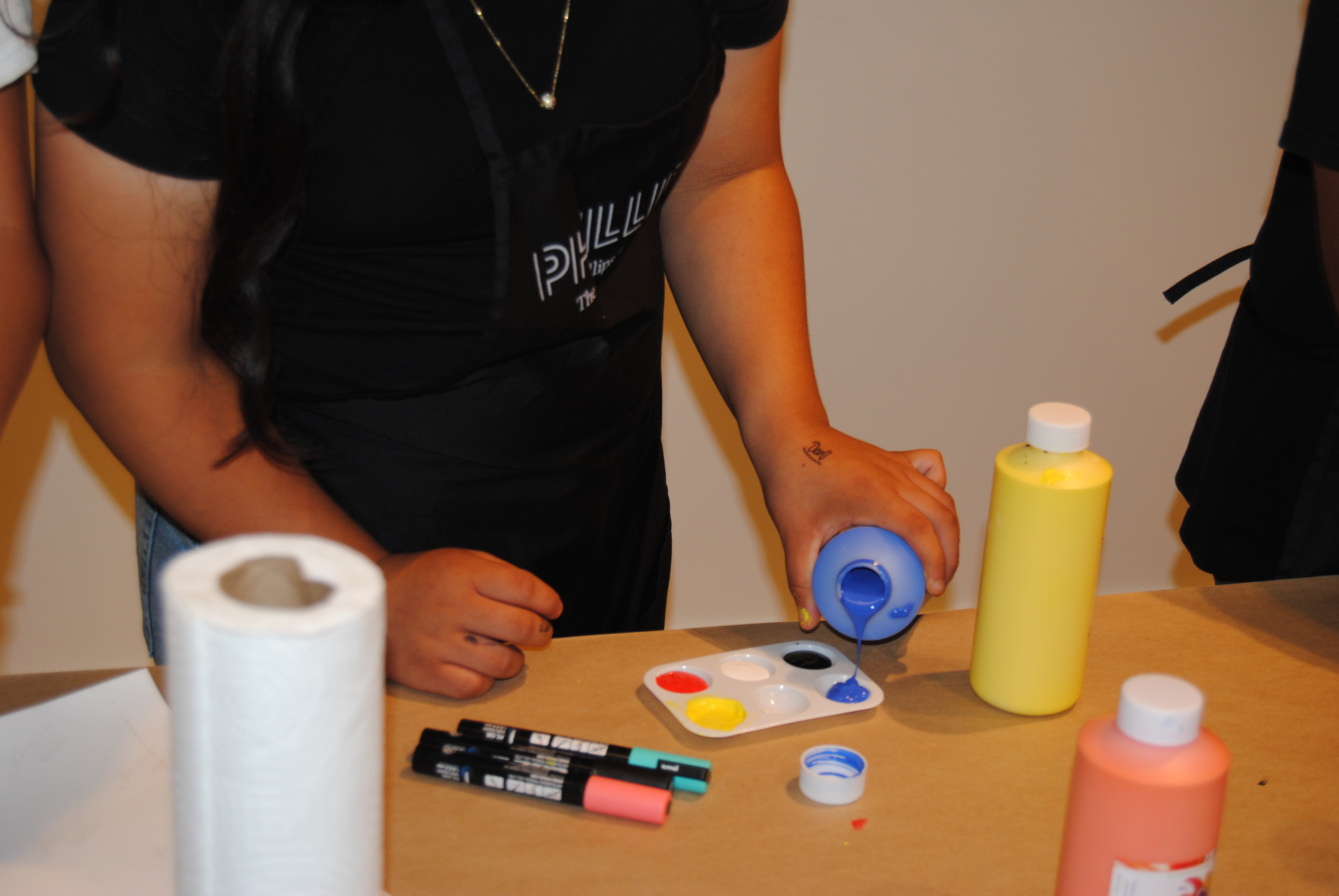 Behind the scenes photo of student using paint on photograph 