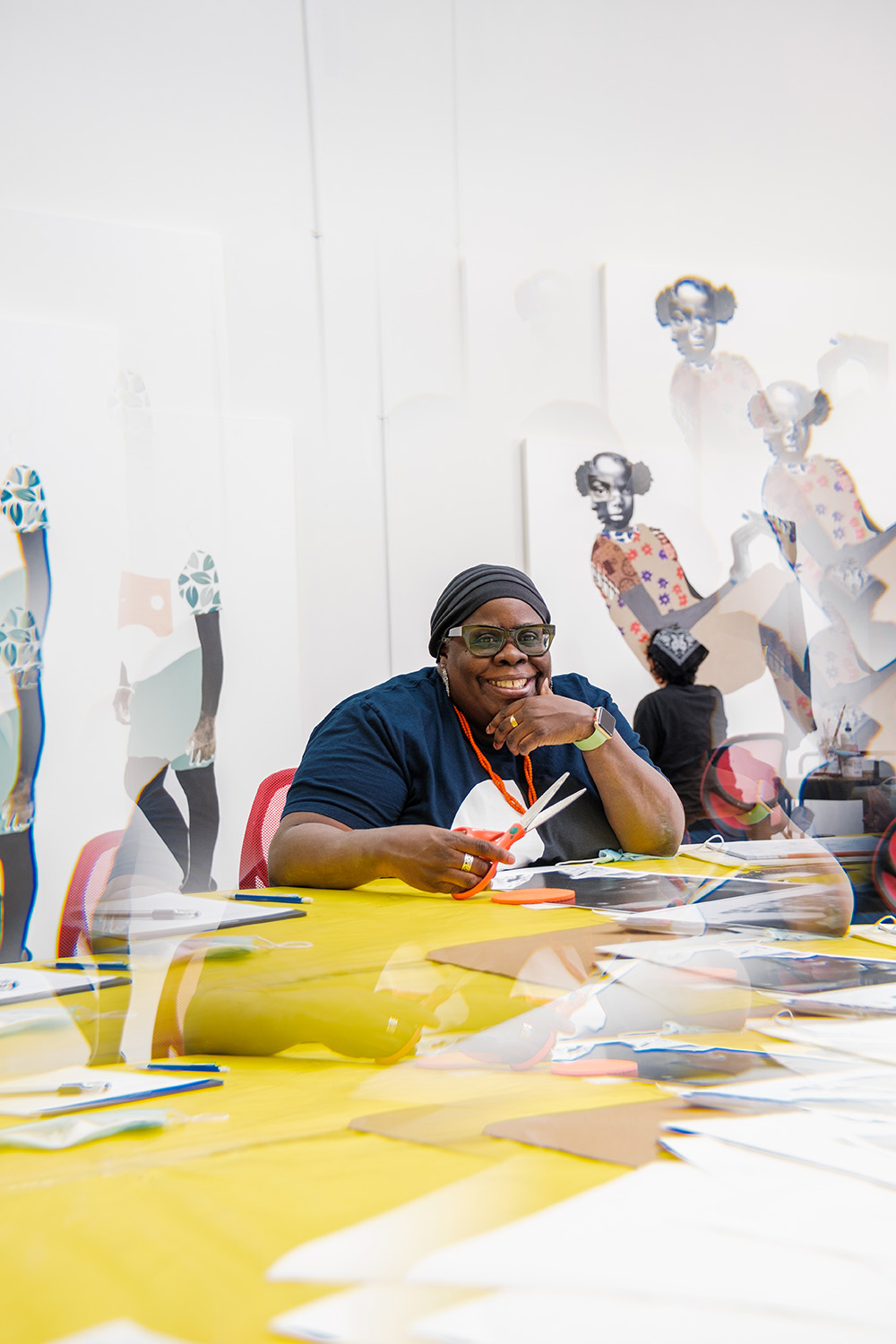 Photograph of Deborah Roberts in her art studio making collages