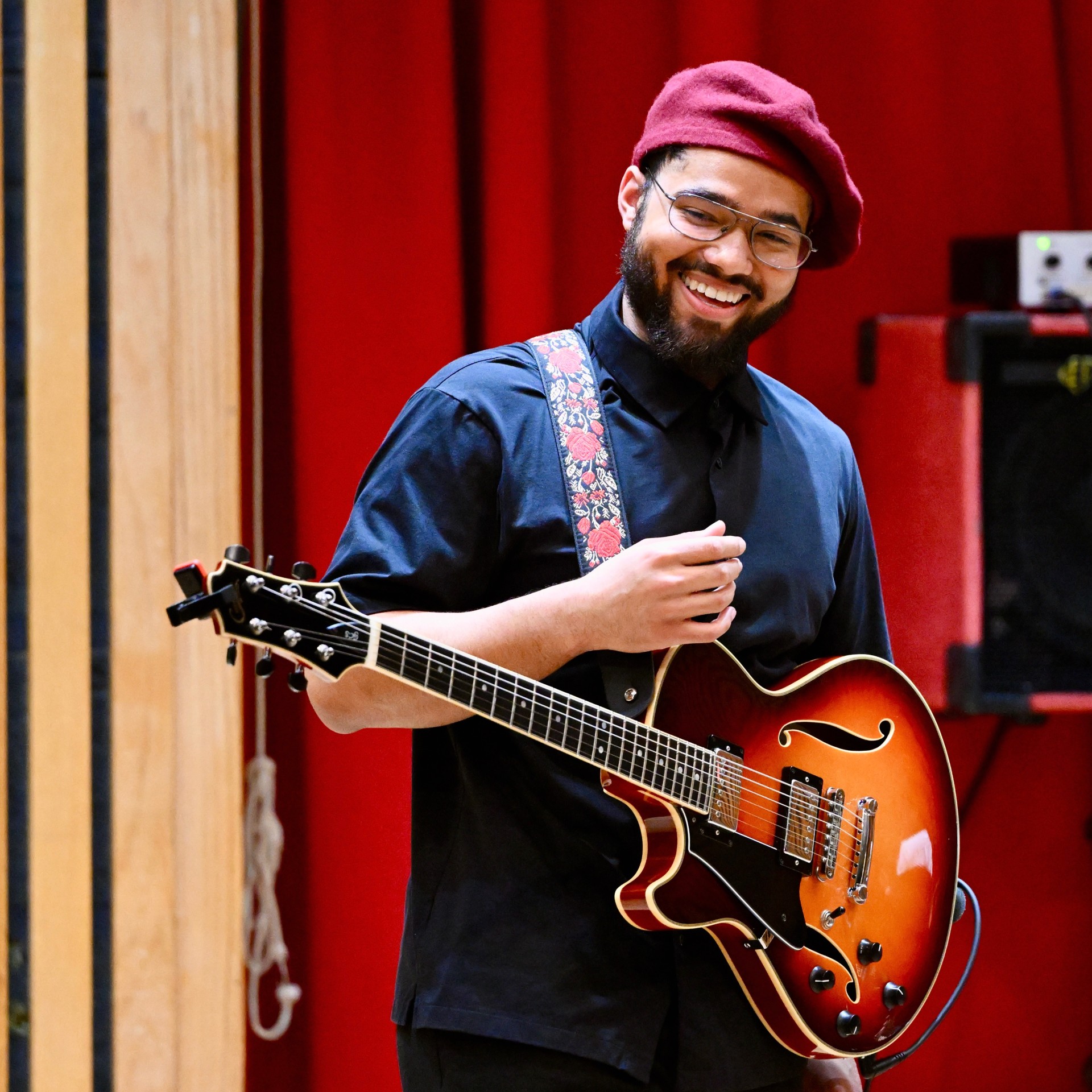 Jackson Dunkin holding a guitar and smiling