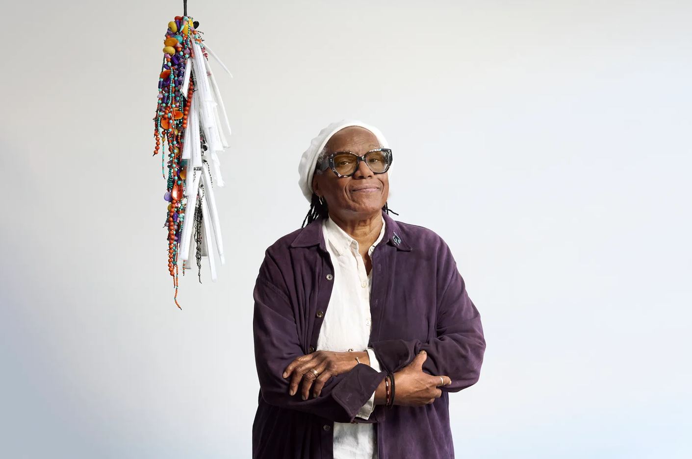 Photograph of Janet Olivia Henry next to a hanging artwork