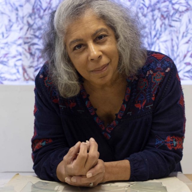 photograph of robin holder leaning on a table and smiling