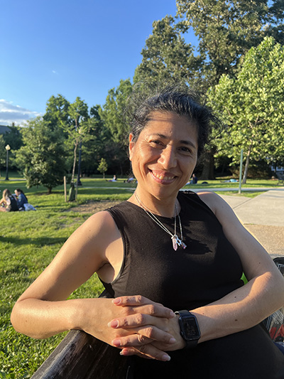 Photograph of Karlisima Rodas-Israel sitting on a bench in a park