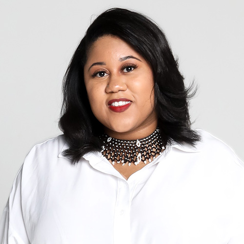 Photograph of Taylor V. Smith in a white shirt and fancy black necklace and white background
