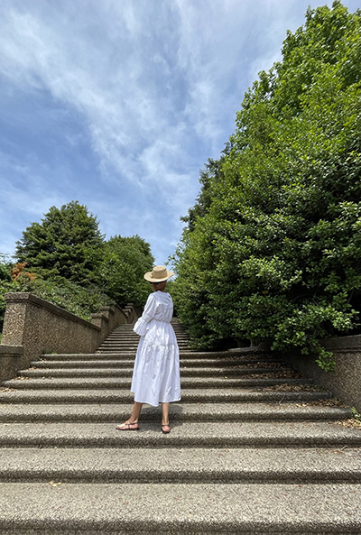 Photograph of Leslie Turner in a white dress walking up steps at a park