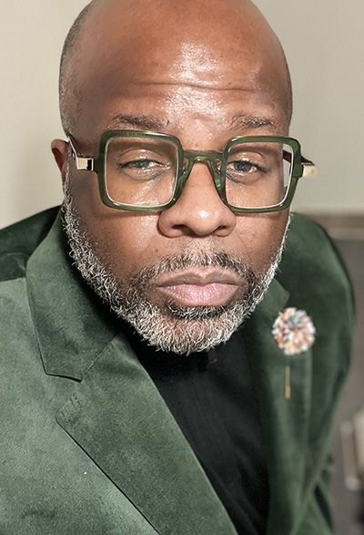 Photograph of Eric Flemming leaning into the camera with eyes squinted