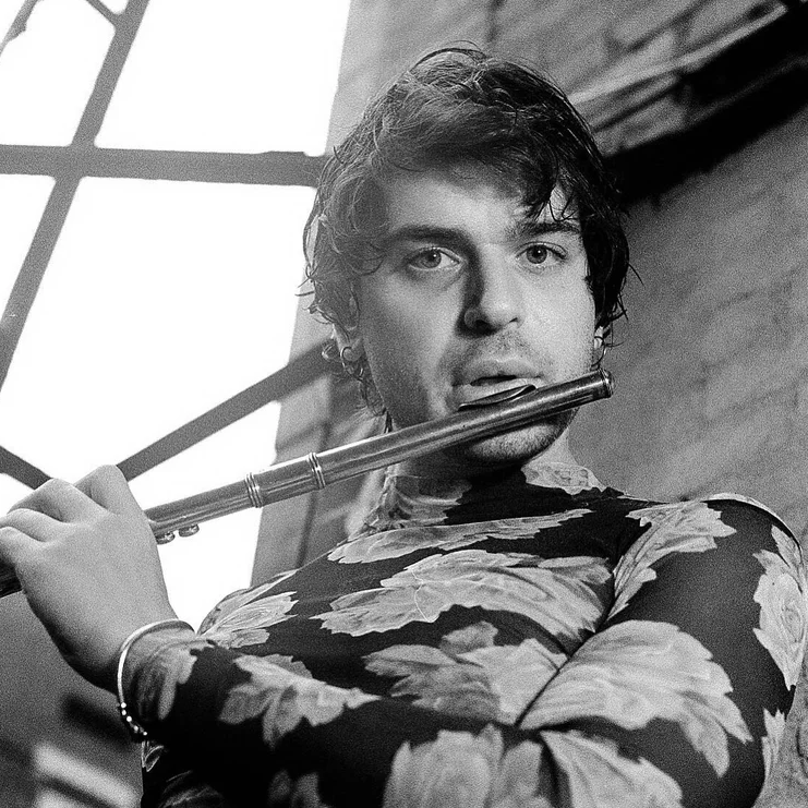 Jacob "NTHNL" Ruding looking at the camera playing the flute
