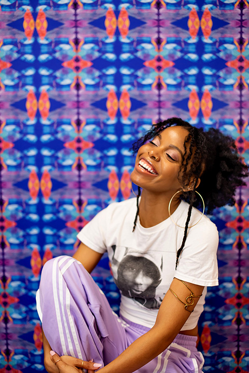 Photo of Aliana Grace Bailey smiling in front of a colorful background
