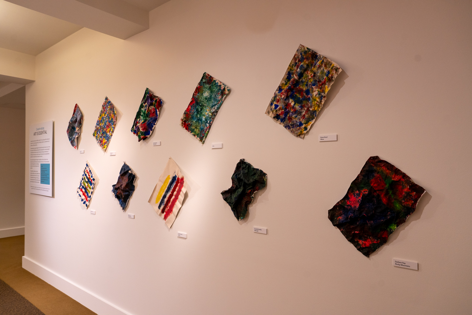Ten colorful artworks displayed on a wall