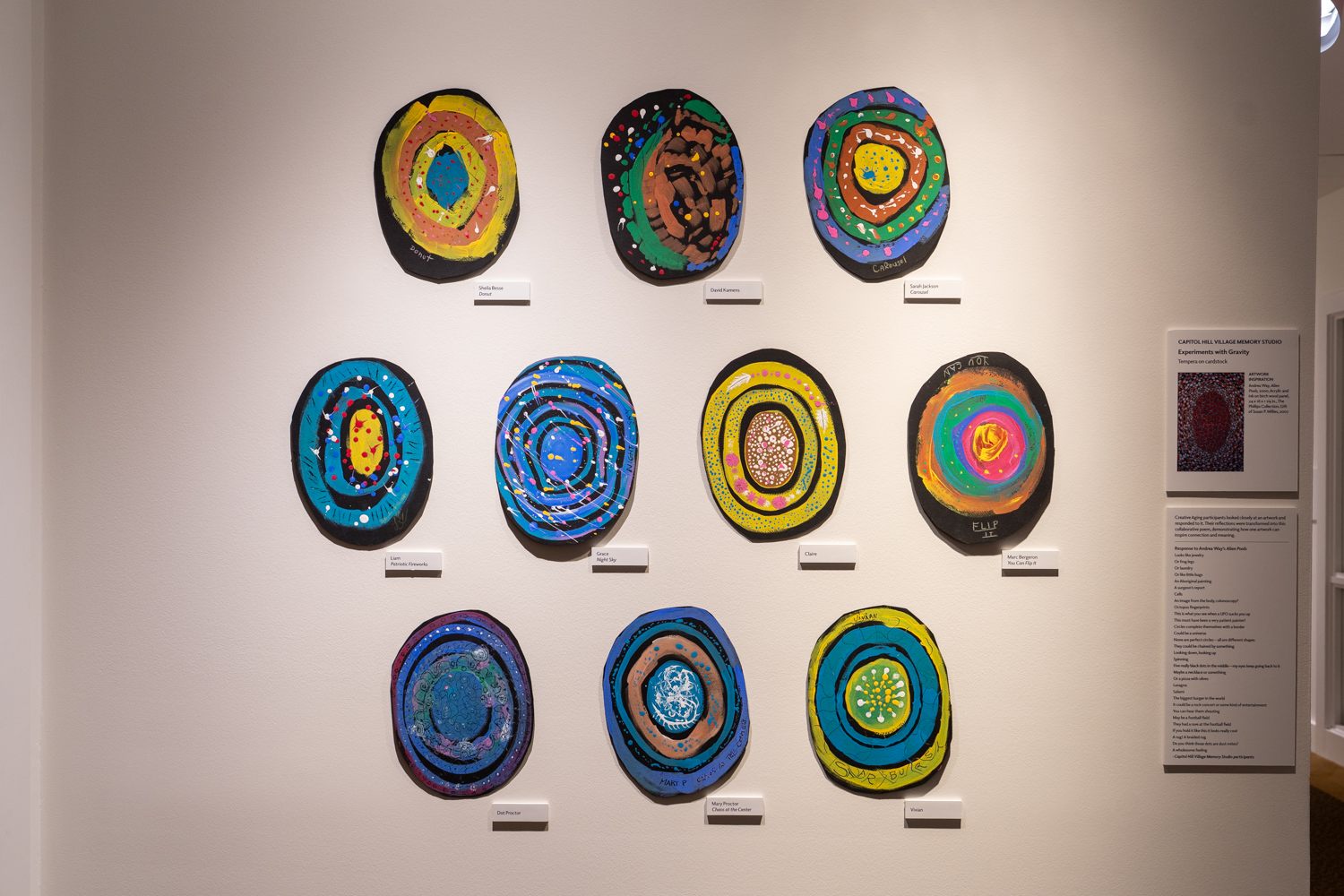 Ten circular artworks displayed on a wall