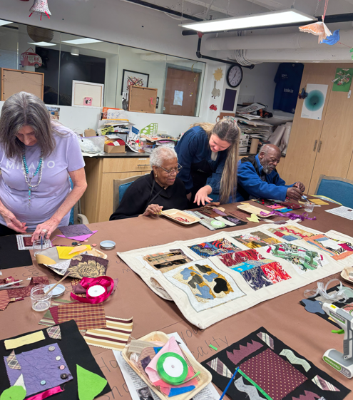 People sitting and standing around a table making abstract collages