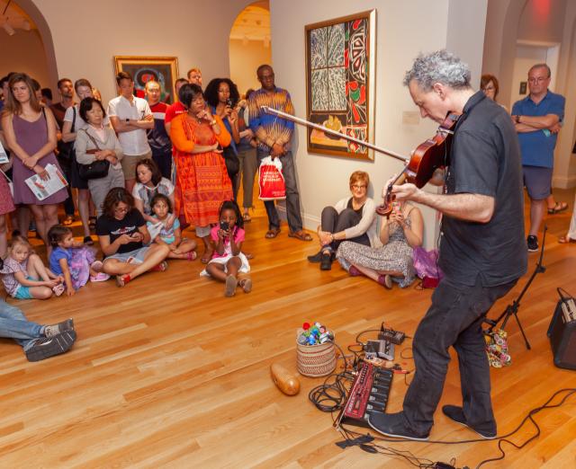 Someone playing the violin to a crowd in the Phillips galleries