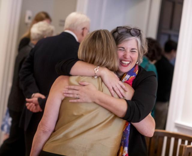 Photo of two people smiling and hugging in the galleries