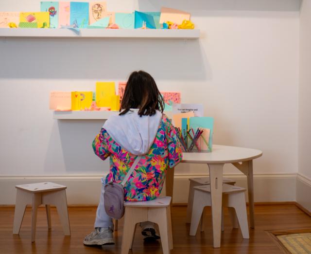 A child sitting at a table making crafts