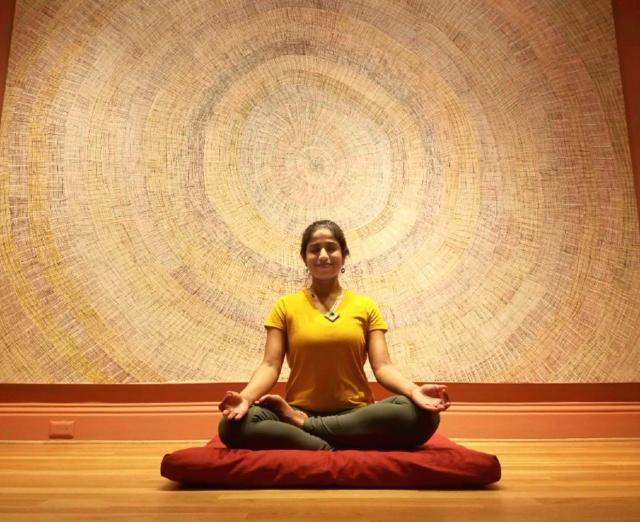 Aparna Sadananda meditating in the Marking the Infinite galleries