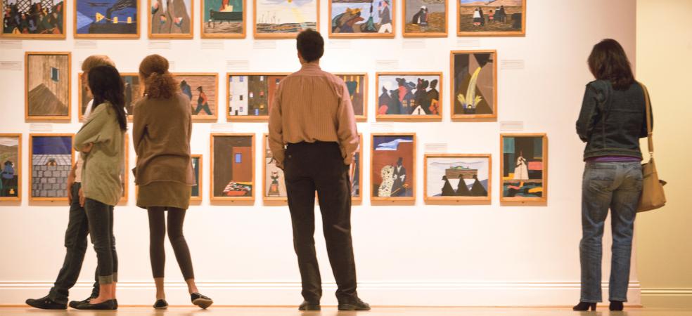 People looking at Jacob Lawrence's Migration Series