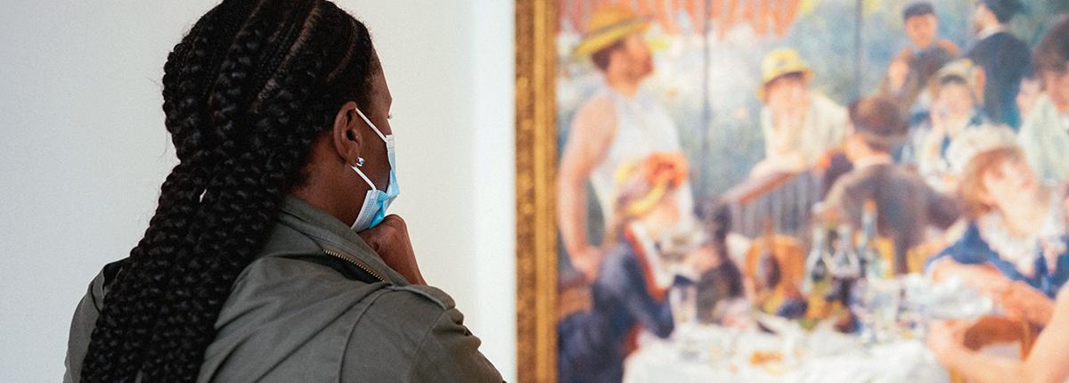 Museum visitor looks at painting