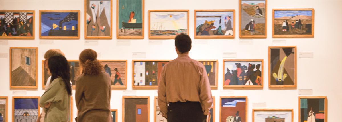 People looking at Jacob Lawrence's Migration Series