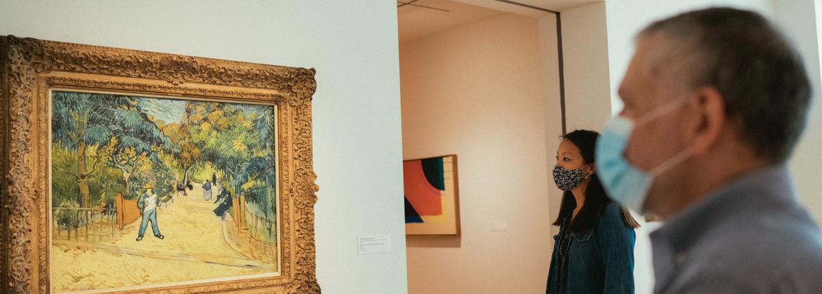 Two people looking at a painting by Van Gogh