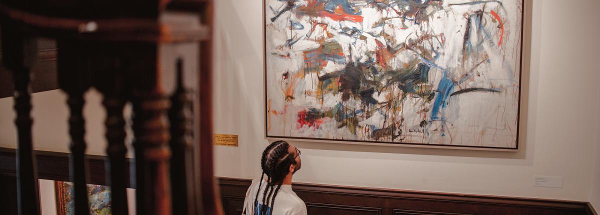 Visitor looking at Joan Mitchell painting in House Stairwell