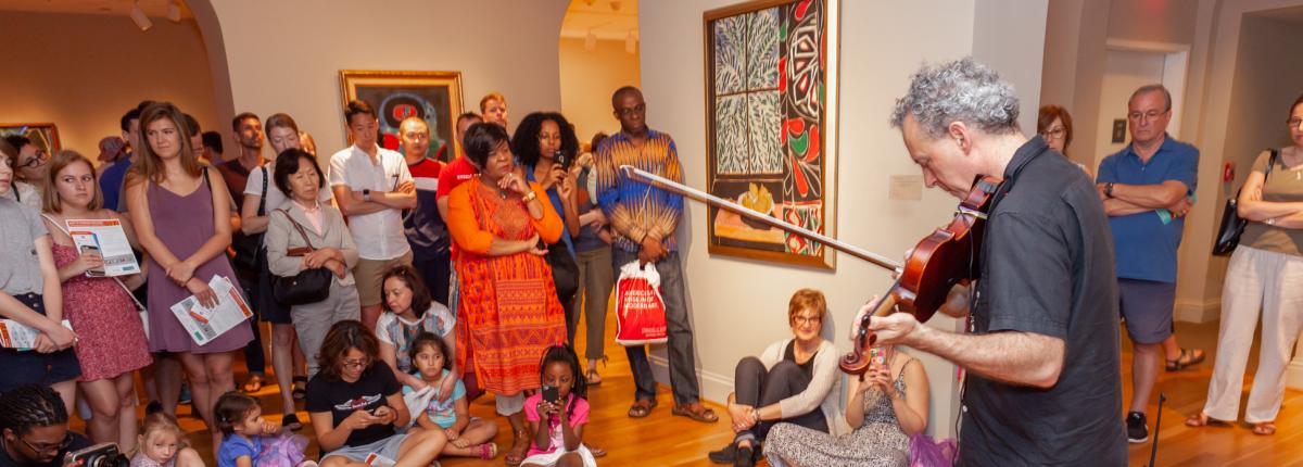 Someone playing the violin to a crowd in the Phillips galleries