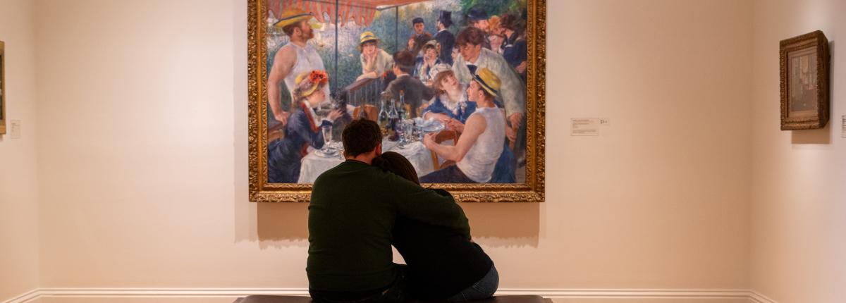 Two people sitting and looking at Luncheon of the Boating Party