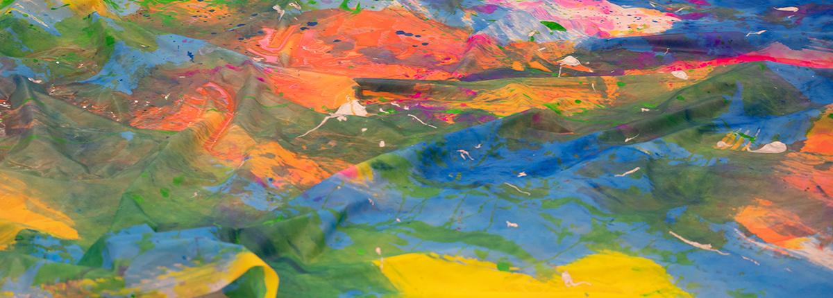 Close up of canvas covered in brightly colored paint