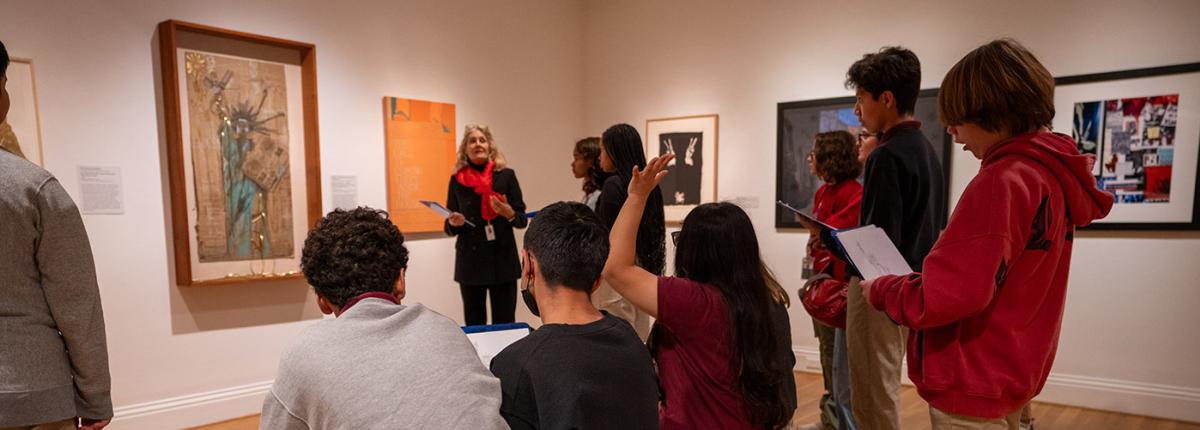 An adult giving a gallery talk to a group of students