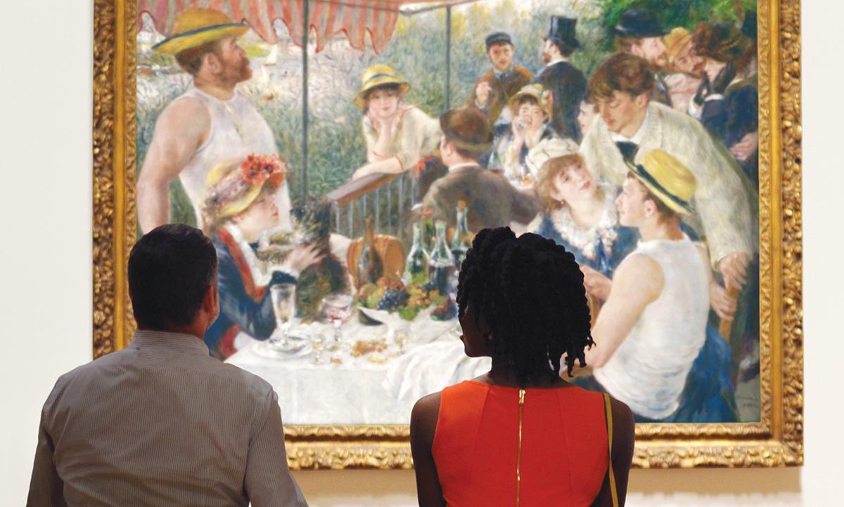 Two people sitting on a bench looking at Renoir's Luncheon of the Boating Party