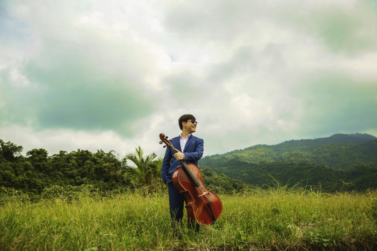 Man in field with cello