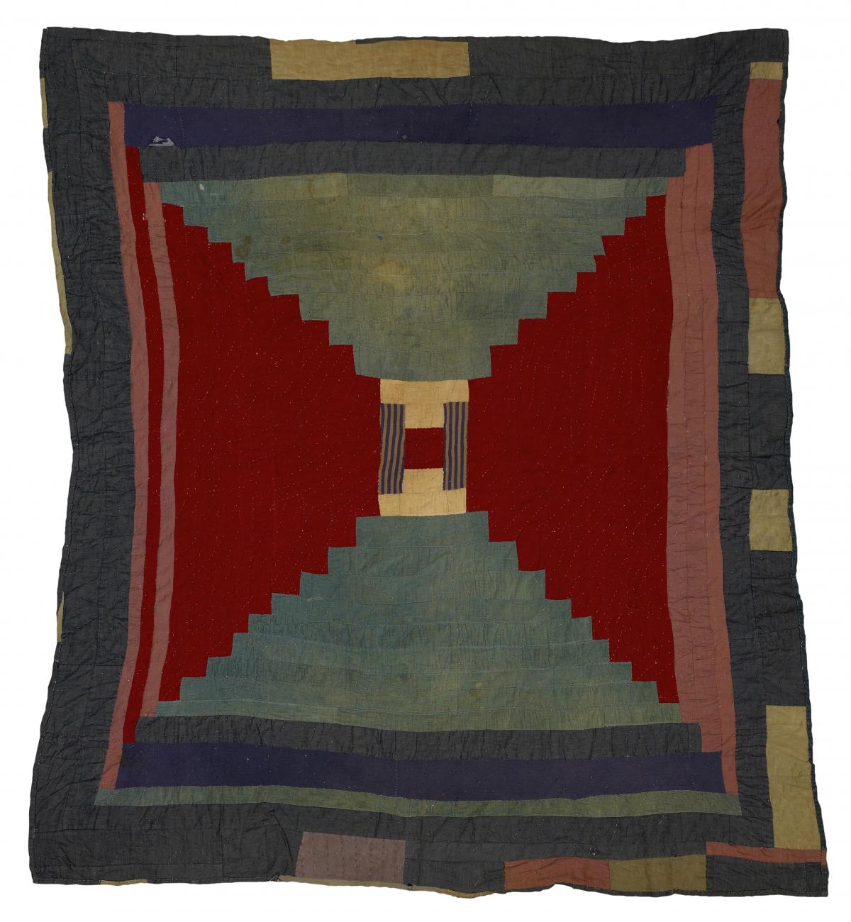 A quilt with red triangles on the sides meeting in the middle, with dark blue border