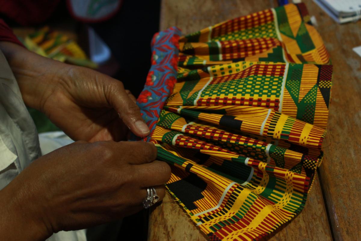 Photo of hands working with fabric with bright color and geometric pattern