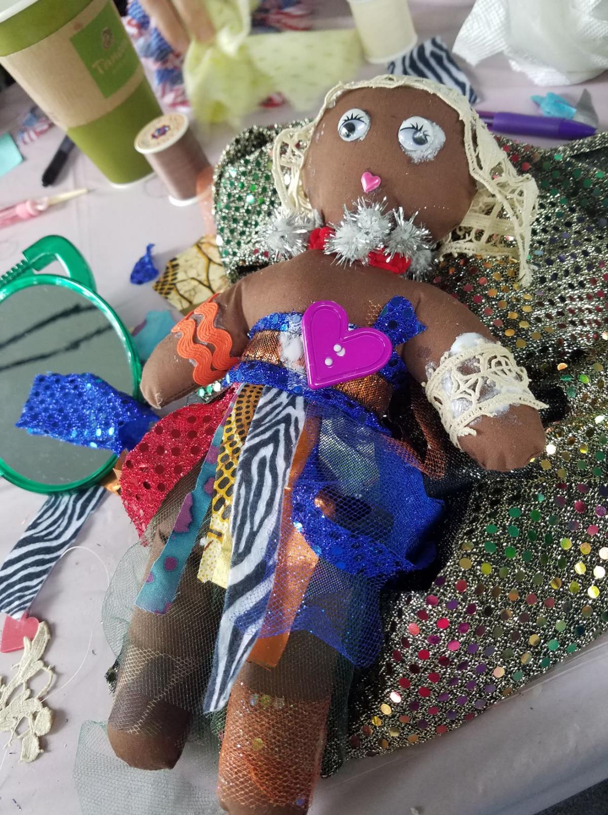 Photo of a hand-made Black baby doll with colorful embellishments