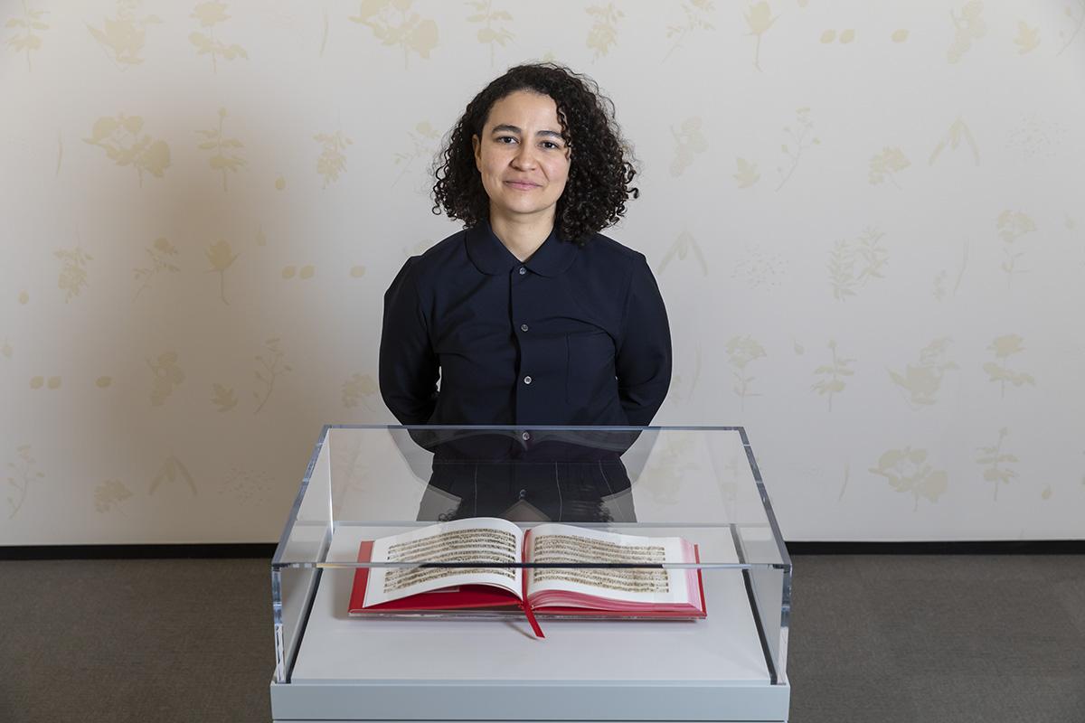 Bethany Collins standing in front of her artist's book in a clear case