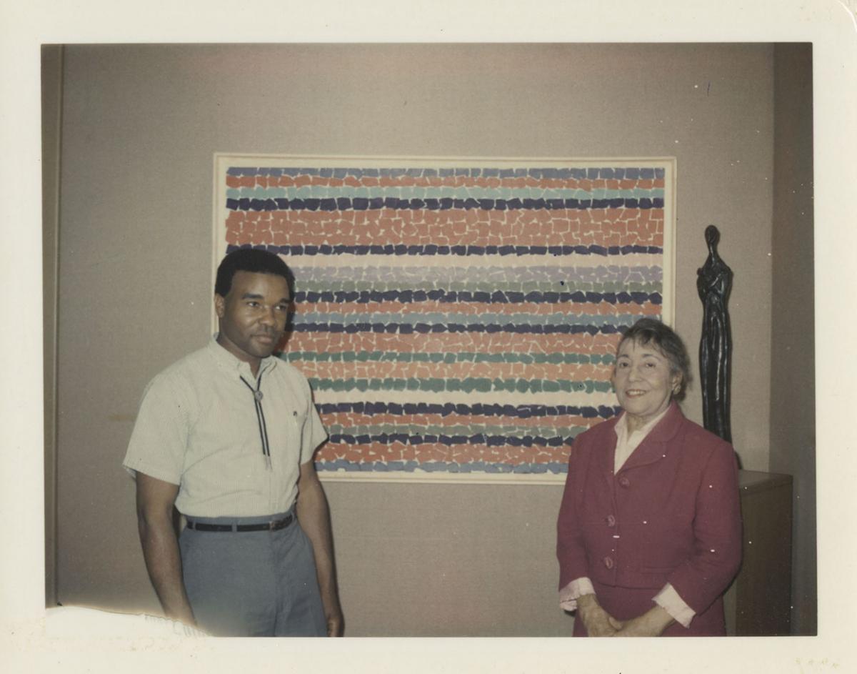 Photograph of David Driskell and Alma Thomas standing in front of a painting by Thomas