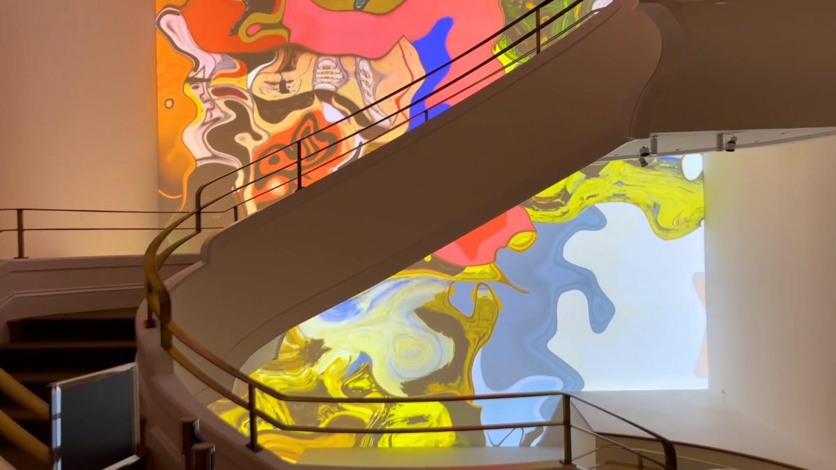 Curved white stairwell with colorful swirling colors on the back wall