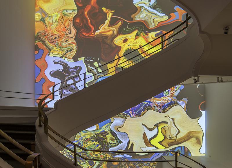 Curved white stairwell with colorful swirling colors on the back wall