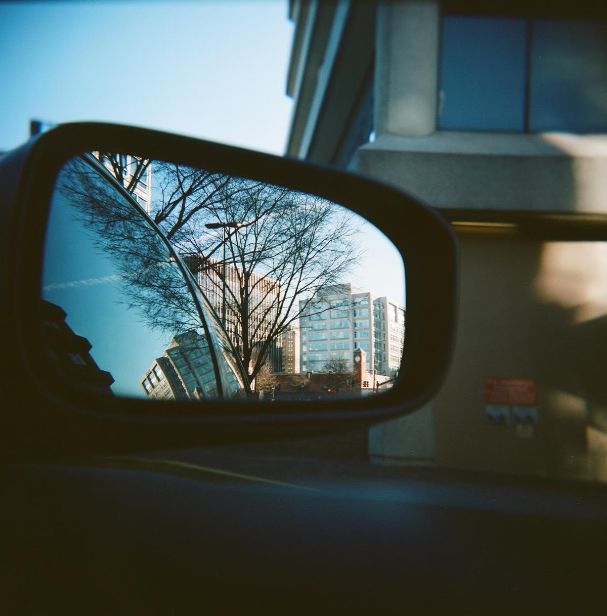 Image of a car's rearview mirror reflecting the city of DC