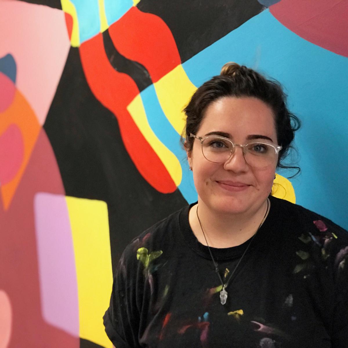 Headshot of Halsey Berryman in front of a colorful wall